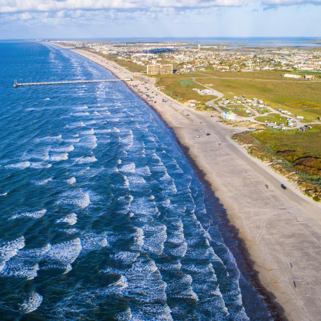 waves in ocean crashing on a beach from a birds-eye view