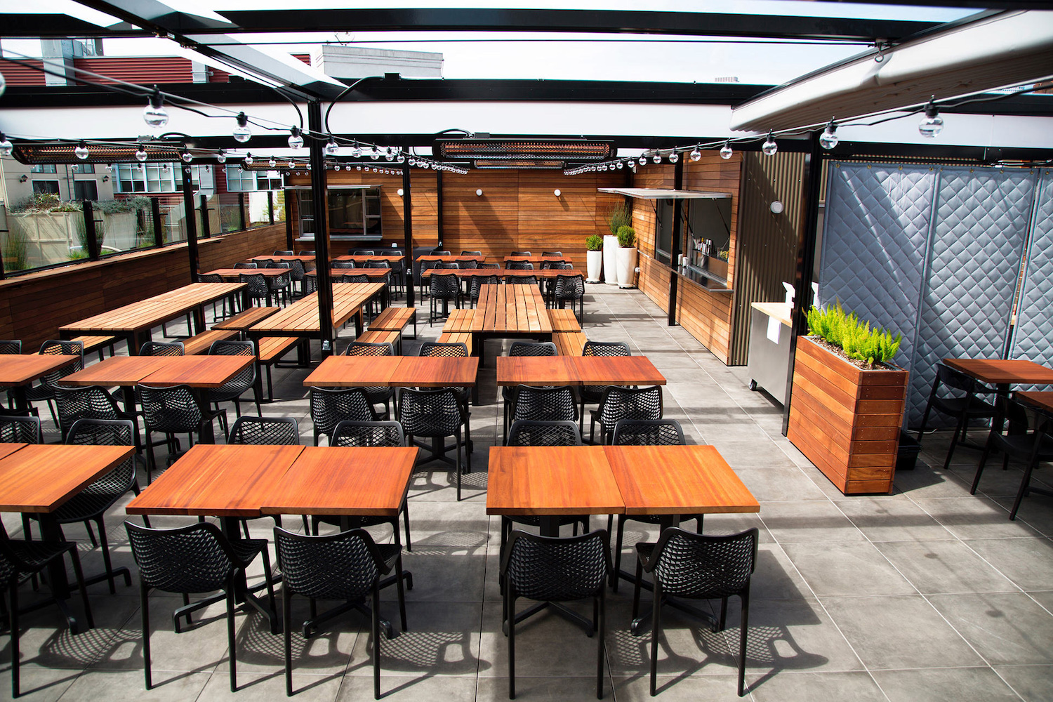 brown tables and chairs on a rooftop.
