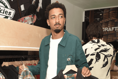 Travis Bennet hold up clothes at an event.