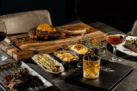 assorted trays of food on black table.