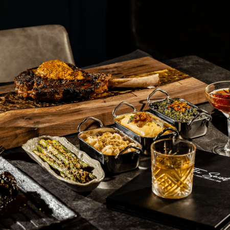 assorted trays of food on black table.