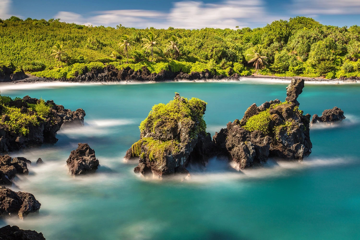Ocean with large rocks in the center in front of private beachy area.