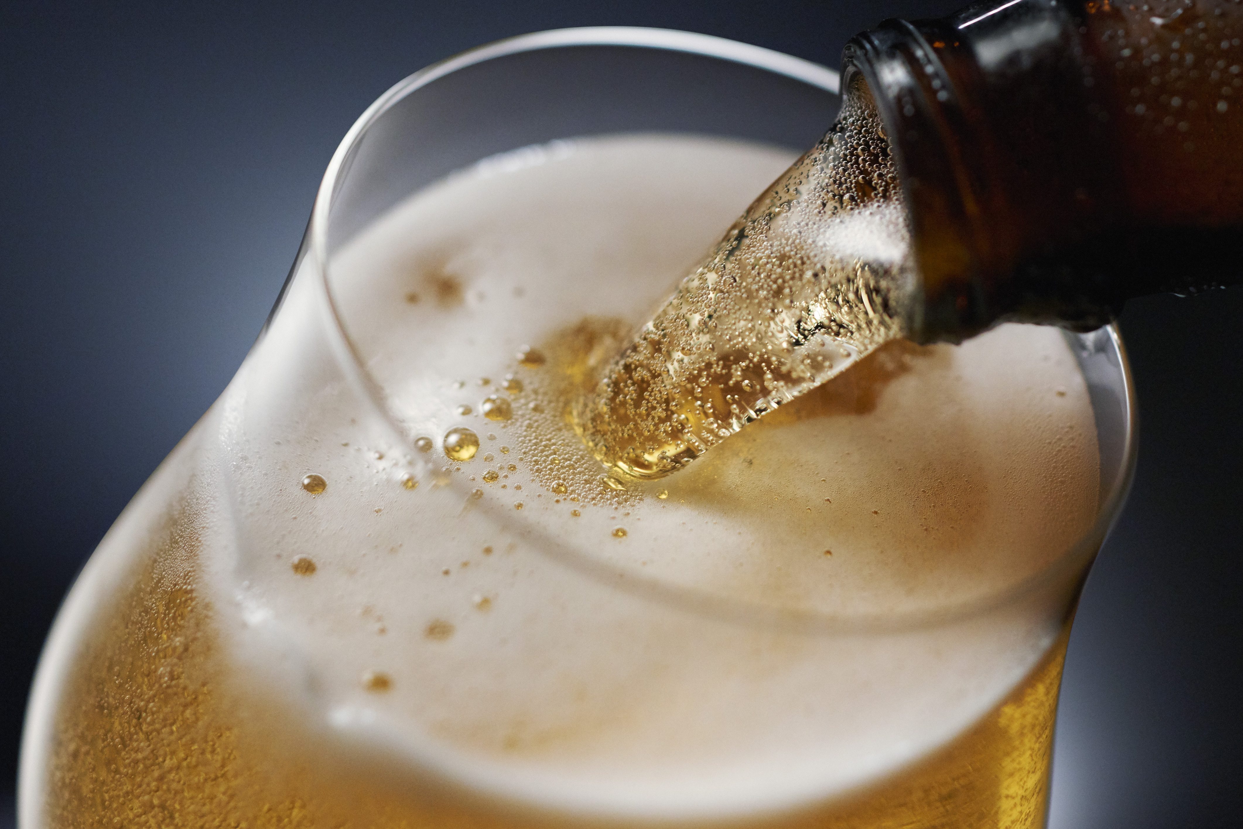 Beer being poured against a dark background.