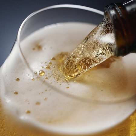 Beer being poured against a dark background.