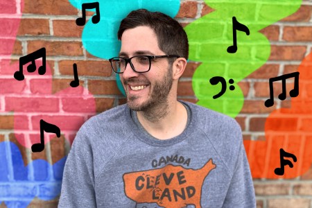 Rob Harvilla posing against a brick wall with musical notes.
