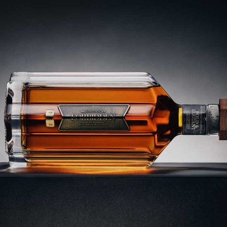 A bottle of Forbidden bourbon on its side