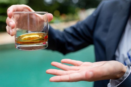 Whiskey in a glass being held by man in suit