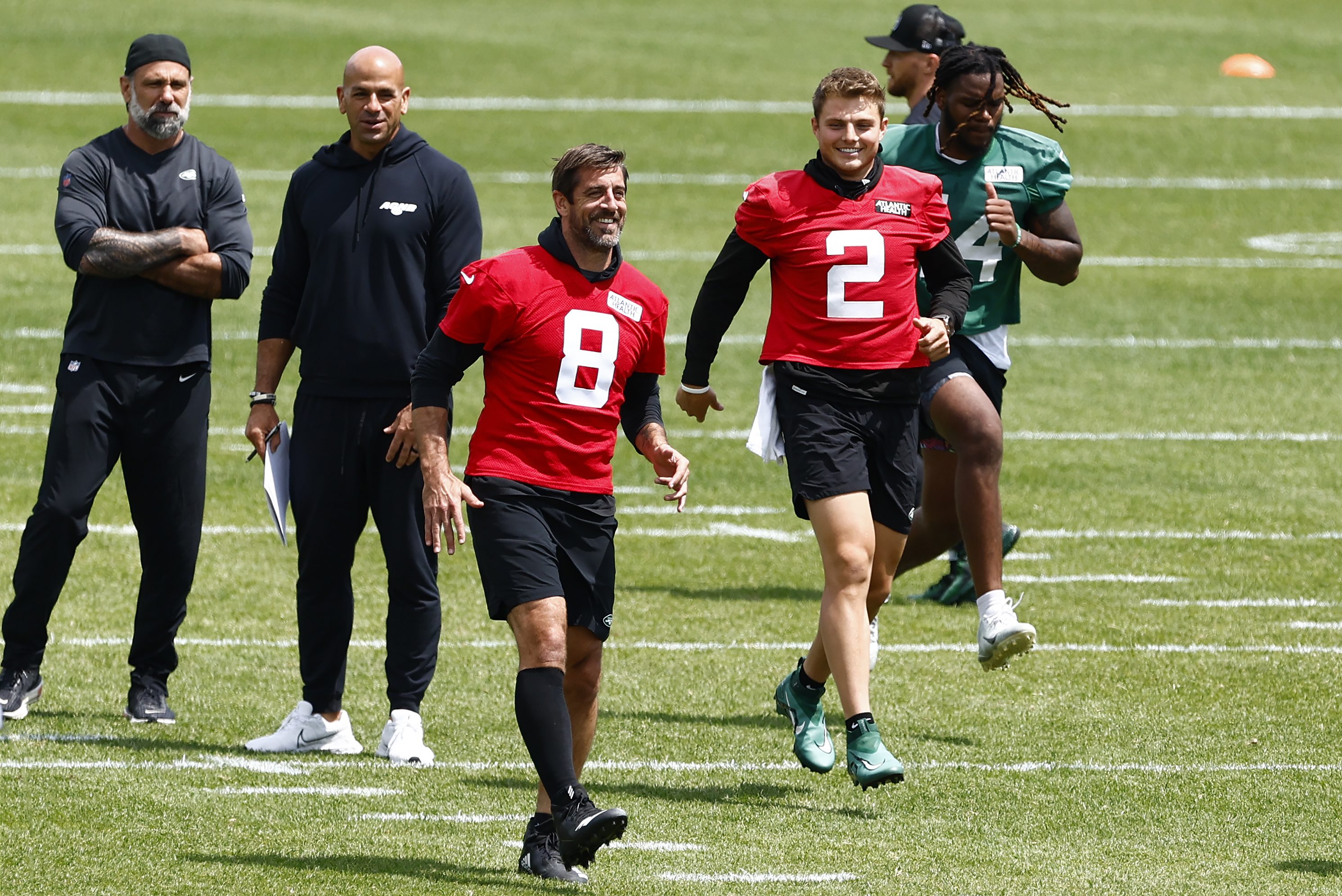 Aaron Rodgers and other New York Jets jog during the team's OTAs.
