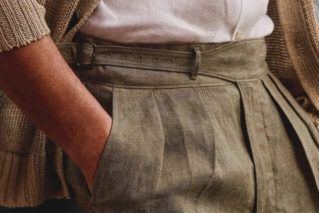 A close-up of a man's linen pants with his hand in his pocket