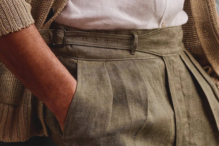 A close-up of a man's linen pants with his hand in his pocket