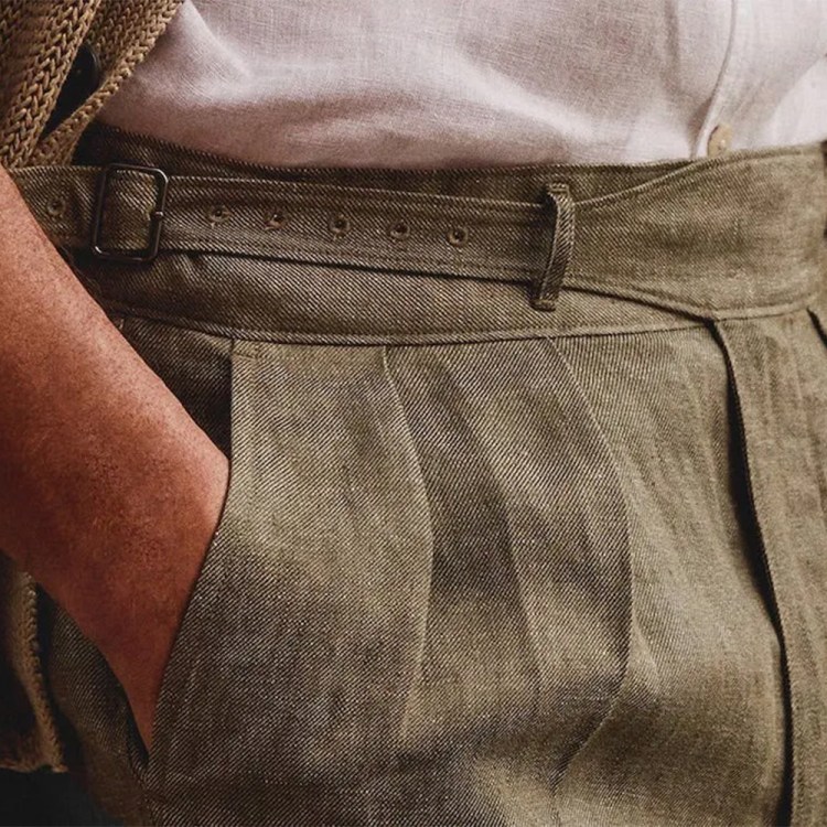 A close-up of a man's linen pants with his hand in his pocket