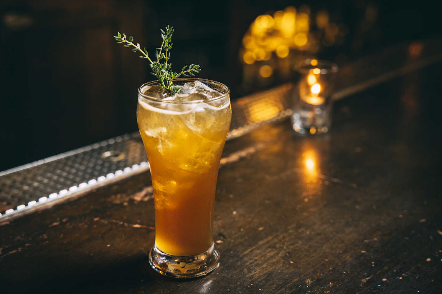 A full cocktail with herb spring on a bar