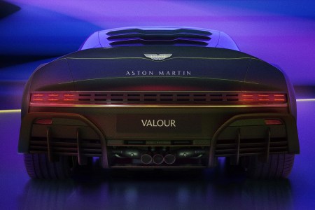 Back of a new Aston Martin car in purple lighting.