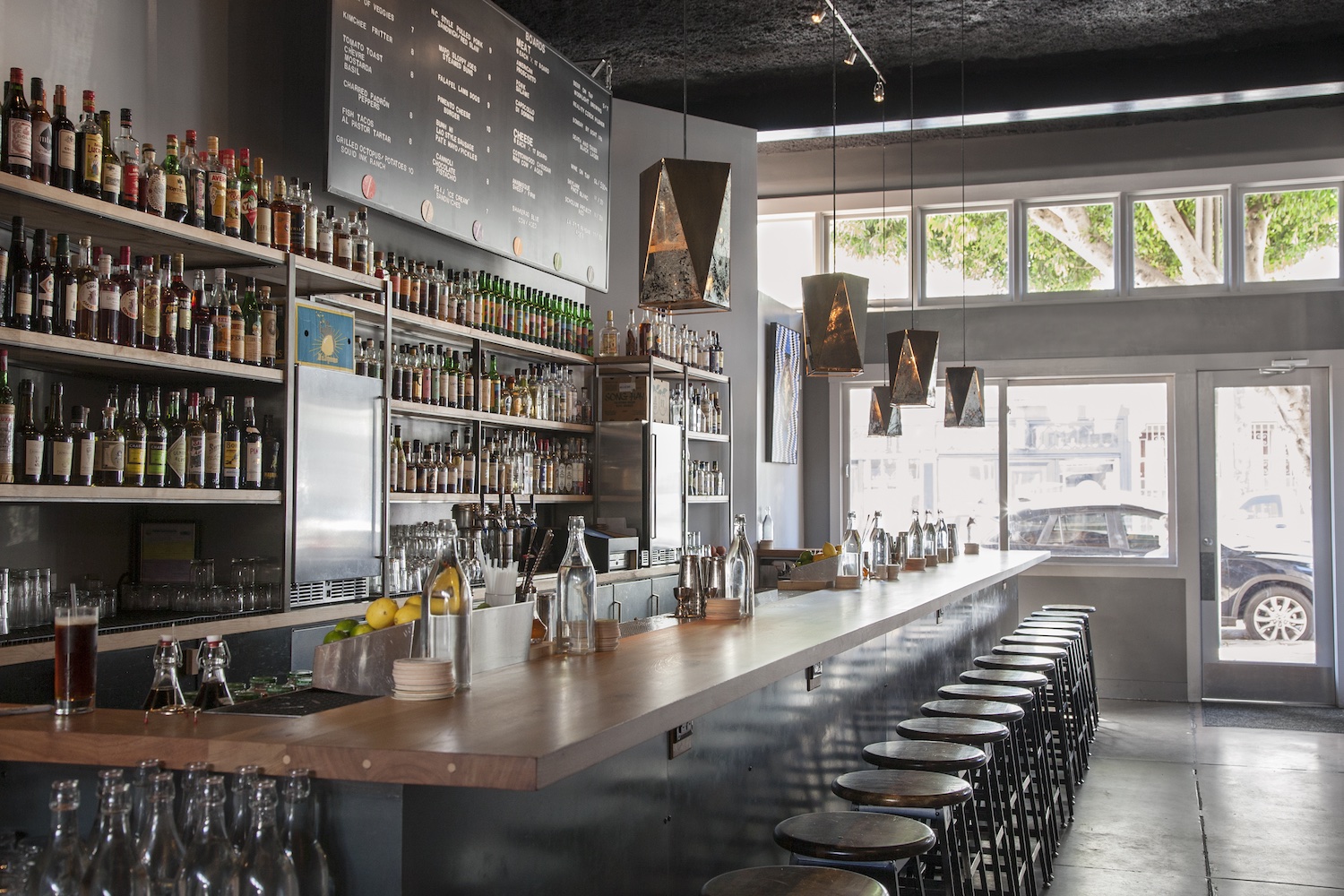 Industrial-designed bar with large shelves that have bottles.