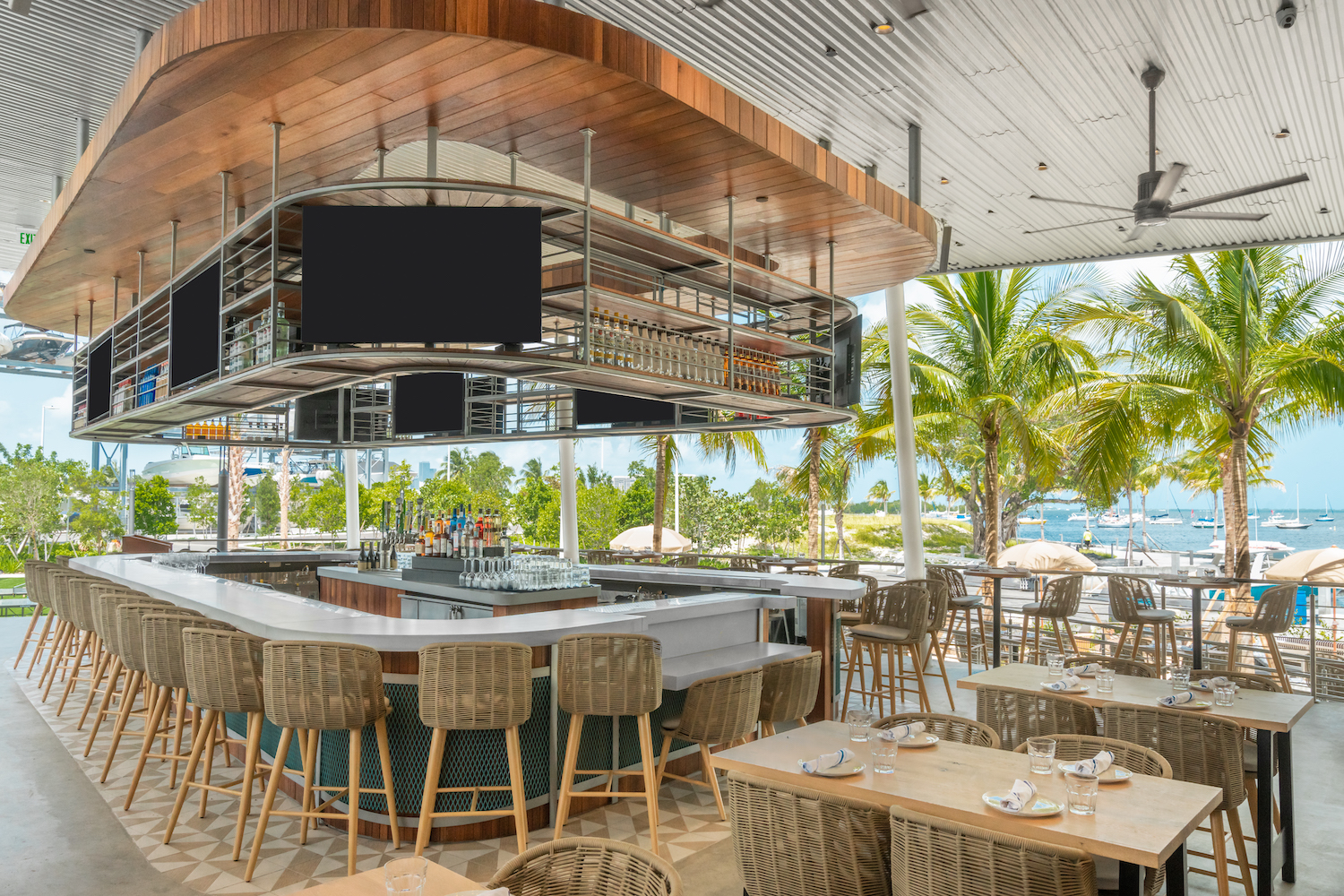 Bar area with tables and chairs on a deck overlooking the water