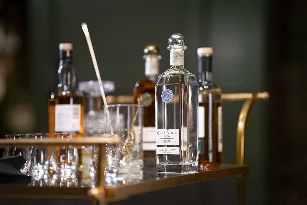 Various Casa Noble bottles on a bar cart
