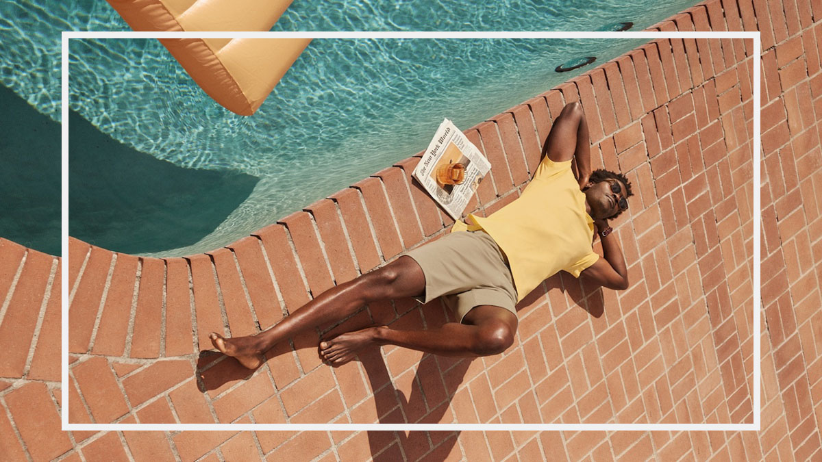 a model in Mack Weldon sale clothes laying by a pool