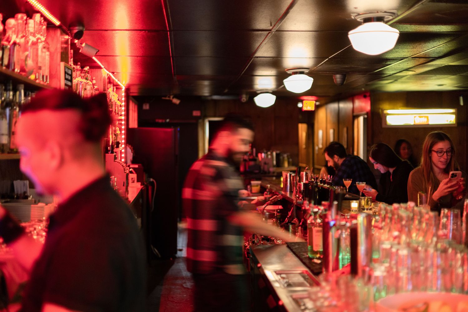 Bartenders making drinks behind a bar counter