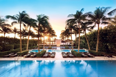Pools with chairs and palm trees.