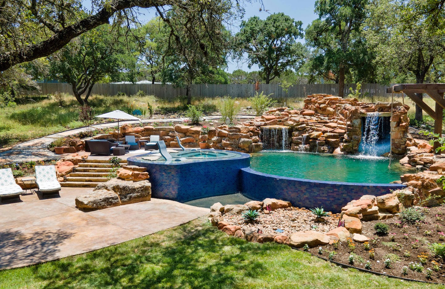 Pool surrounded by rock architecture and rope swing.