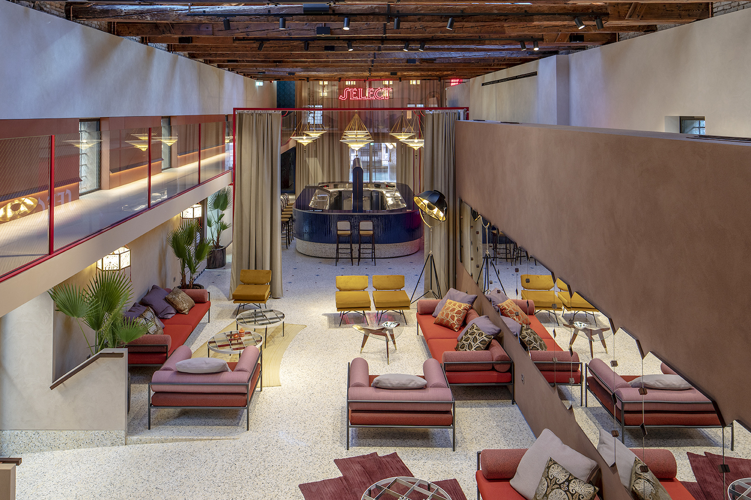 Vibrant-colored room with retro aesthetic with lounge chairs and a bar.