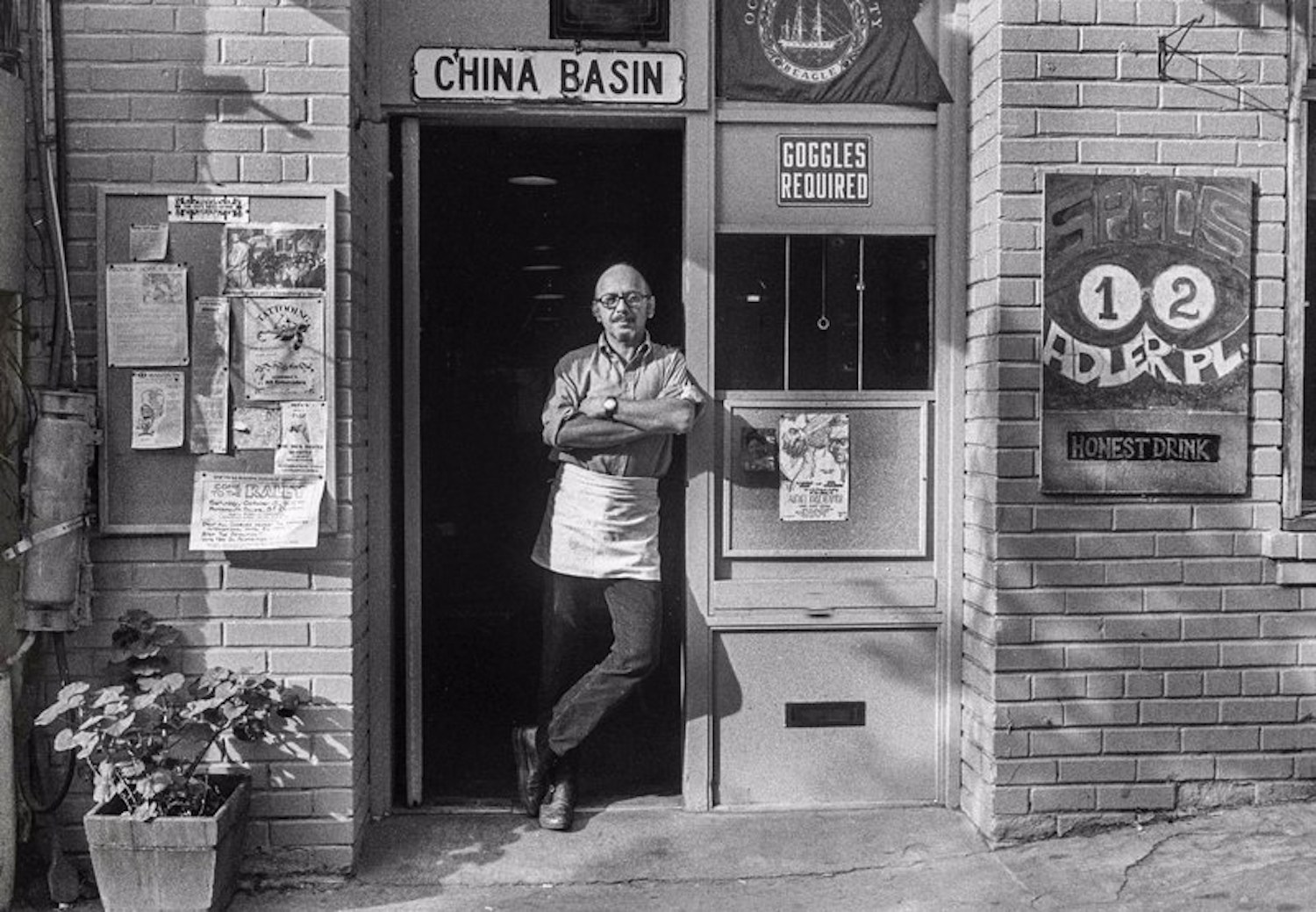 Black and white photo of man standing in a doorway.