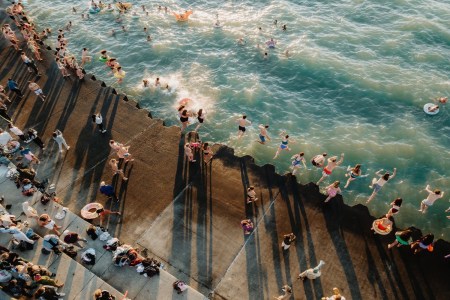 people jumping into lake to swim.