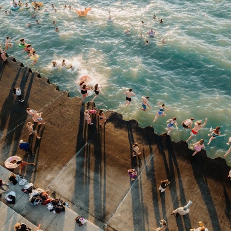 people jumping into lake to swim.