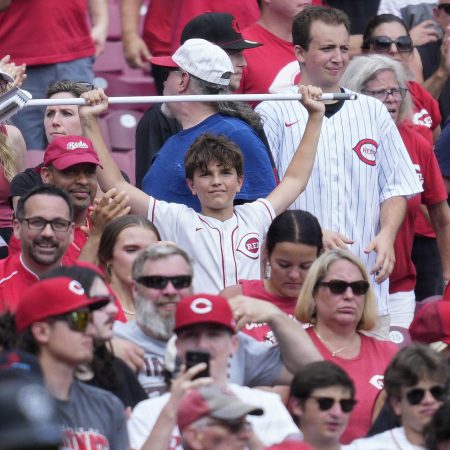 A young fan holds up a broom during a game.