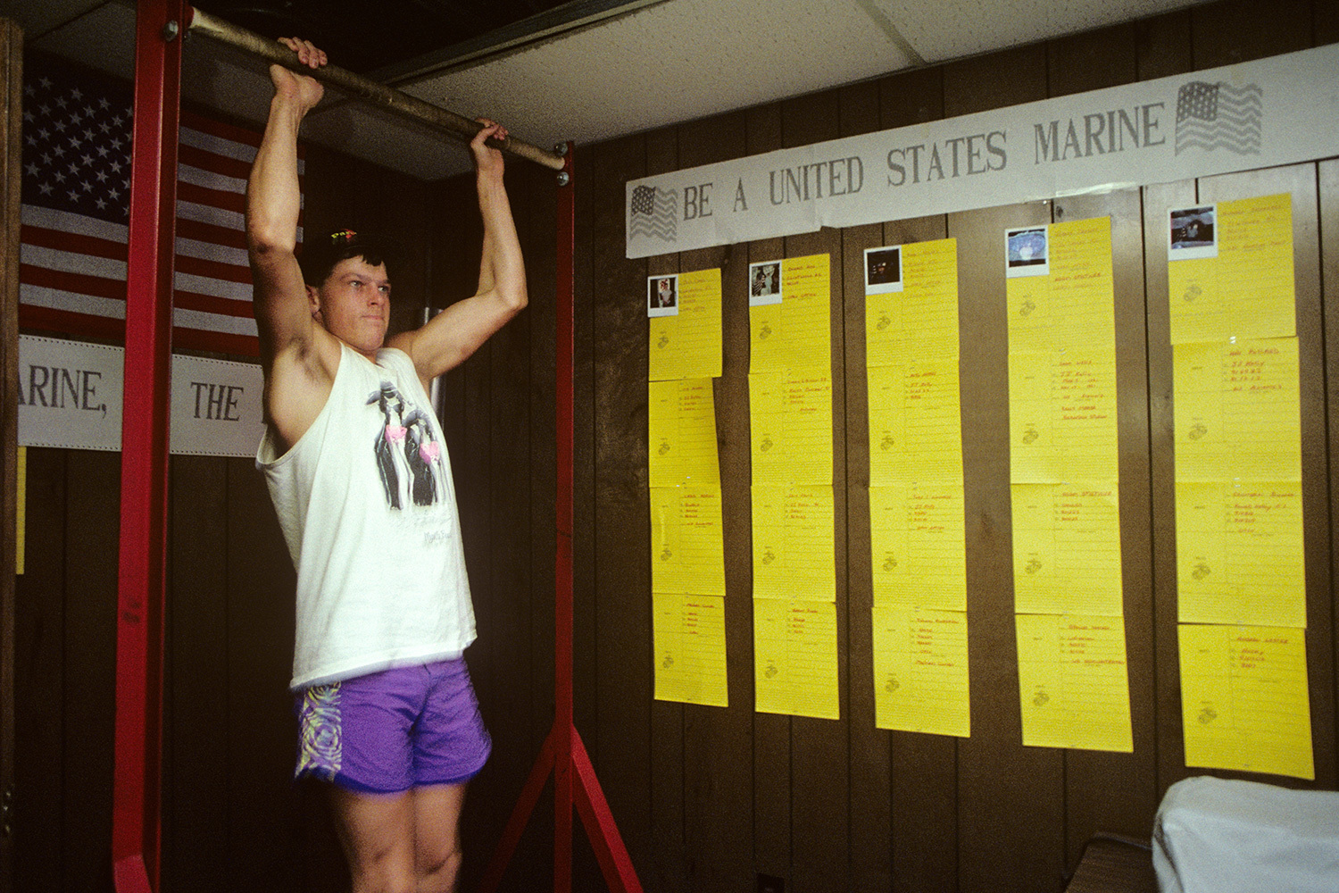 A Marine recruit performing pull-ups in an old-school facility.
