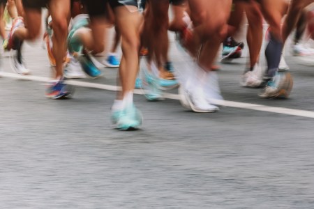 An artistically blurry photo of runners' legs zooming by in a race.