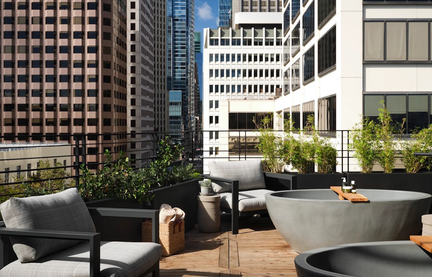 Rooftop tubs on top of a hotel building with skyscrapers in background