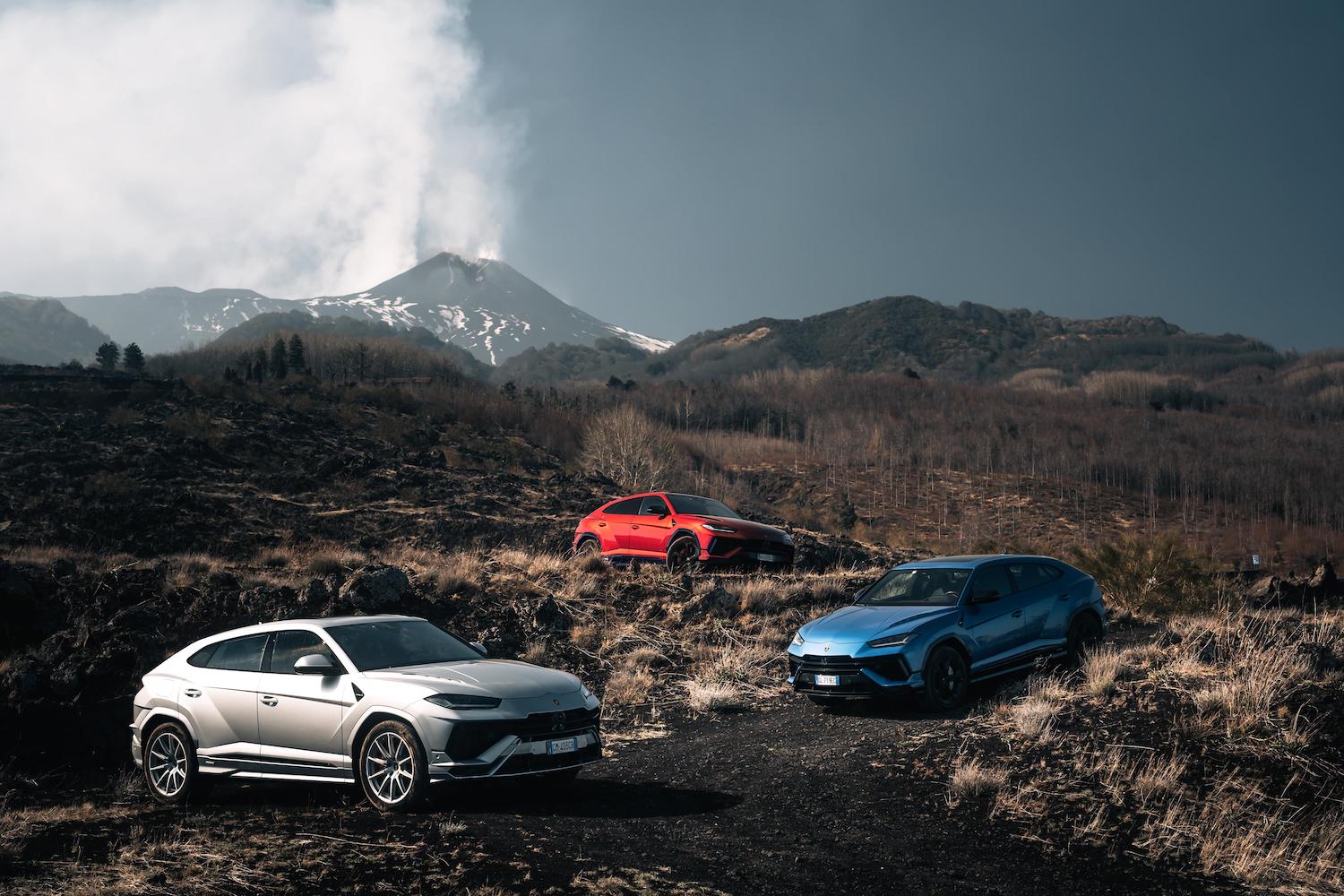 Three different colored Lamborghinis on a mountain.