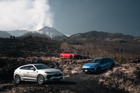 Three different colored Lamborghinis on a mountain.