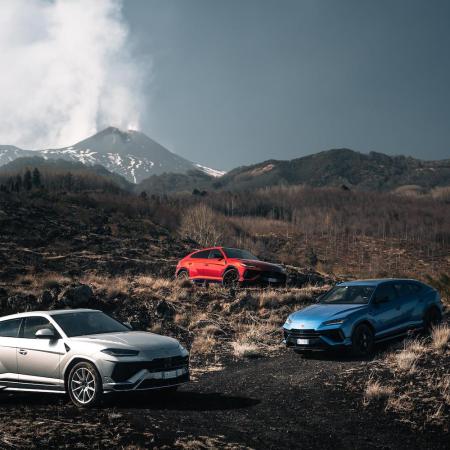 Three different colored Lamborghinis on a mountain.