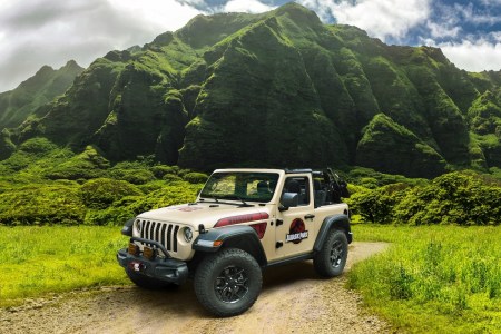 Jeep with graphics in grassy landscape.