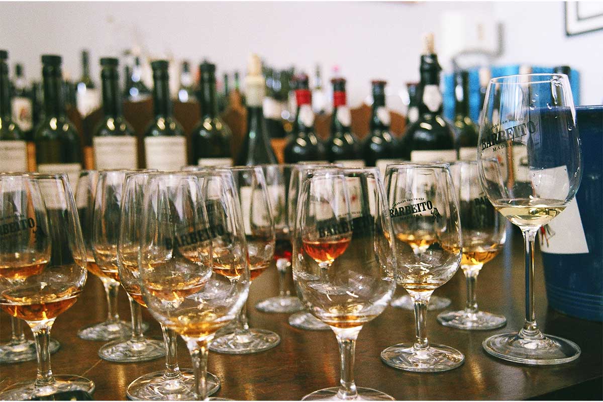 Several glasses and bottles of Barbeito's wine from Madeira