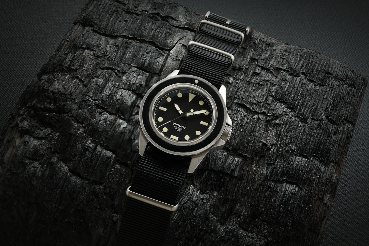 A Unimatic watch on a black background