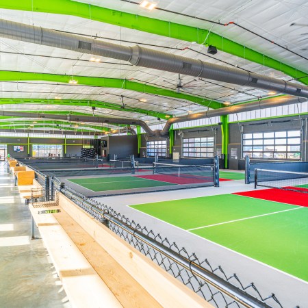 Neon green indoor pickleball courts at Chicken N Pickle in Texas