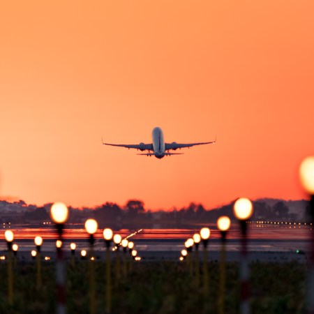 Airplane taking off at sunrise