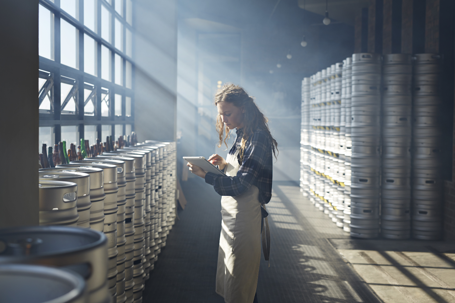 Female waiter counting beer keg's using tablet