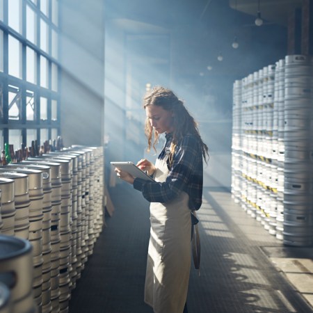 Female waiter counting beer keg's using tablet