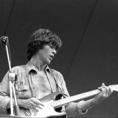 Robbie Robertson plays his Fender Stratocaster electric guitar as he performs outside onstage in June 1976.