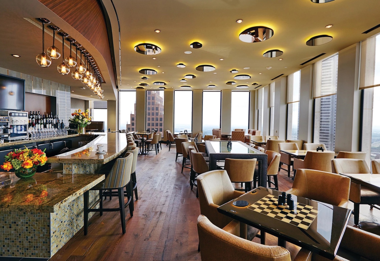 Tables overlooking floor-to-ceiling windows in a restaurant.