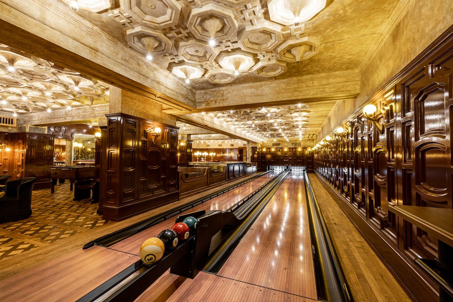 Two bowling lanes in an open room with unique interior design
