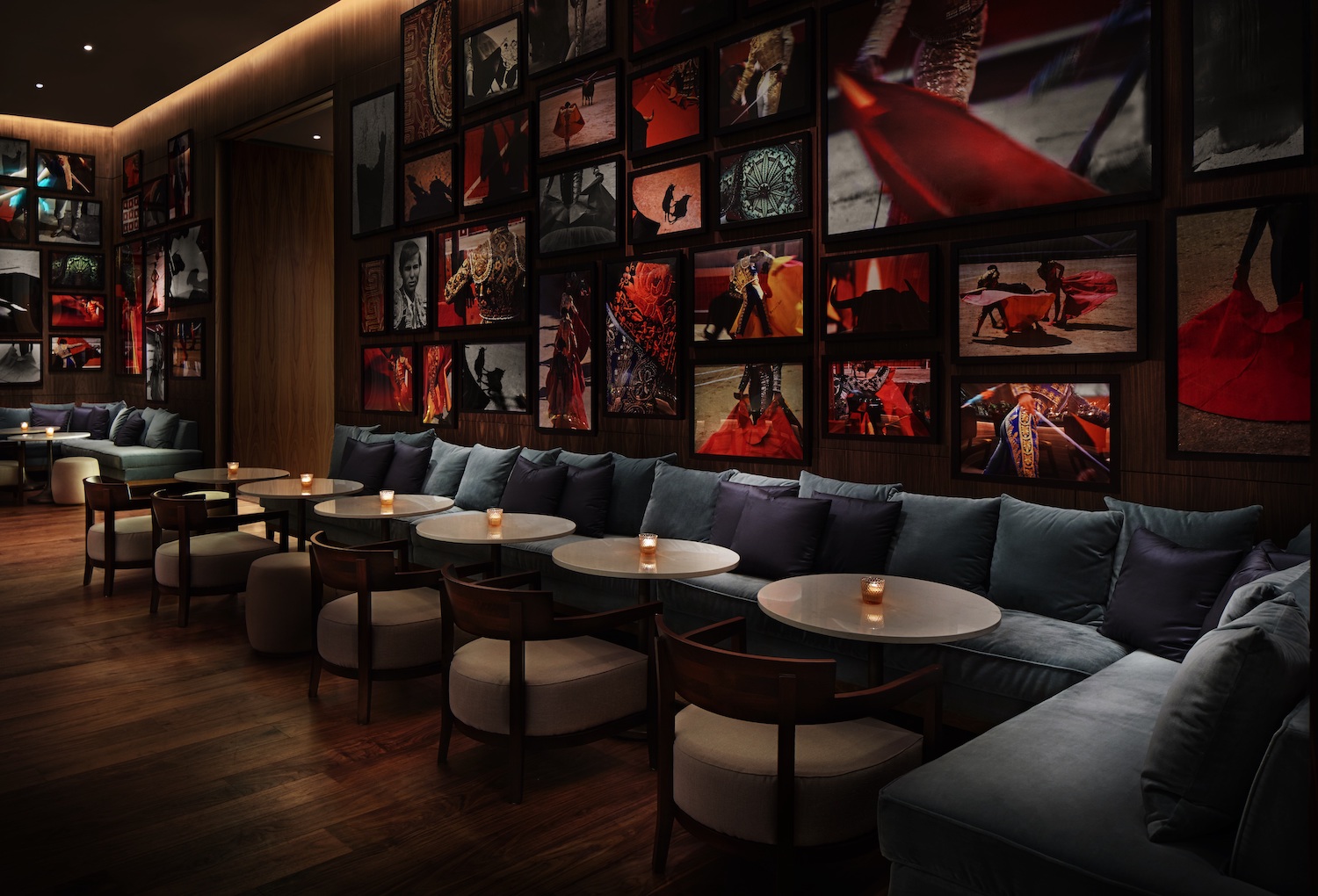 Booth seats and tables in front of a wall with colorful framed pictures