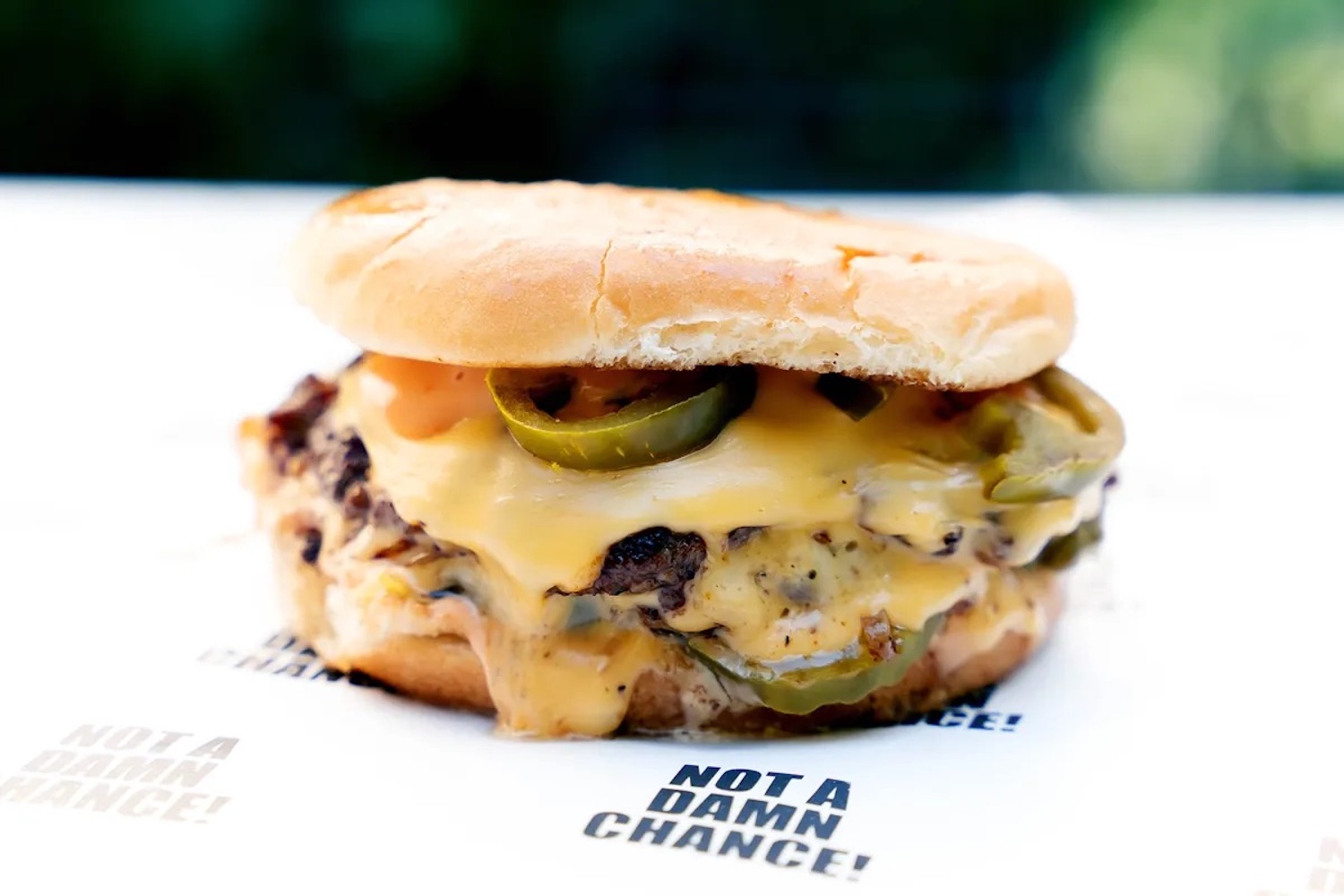 NADC burger with cheese and jalapeños on a bun.