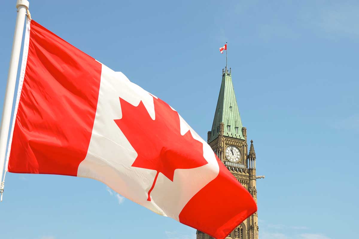 Canadian flag waving in front of the Parliament Building on Parliament Hill in Ottawa. A new AI-generated travel article suggested tourists visit the Ottawa Food Bank.