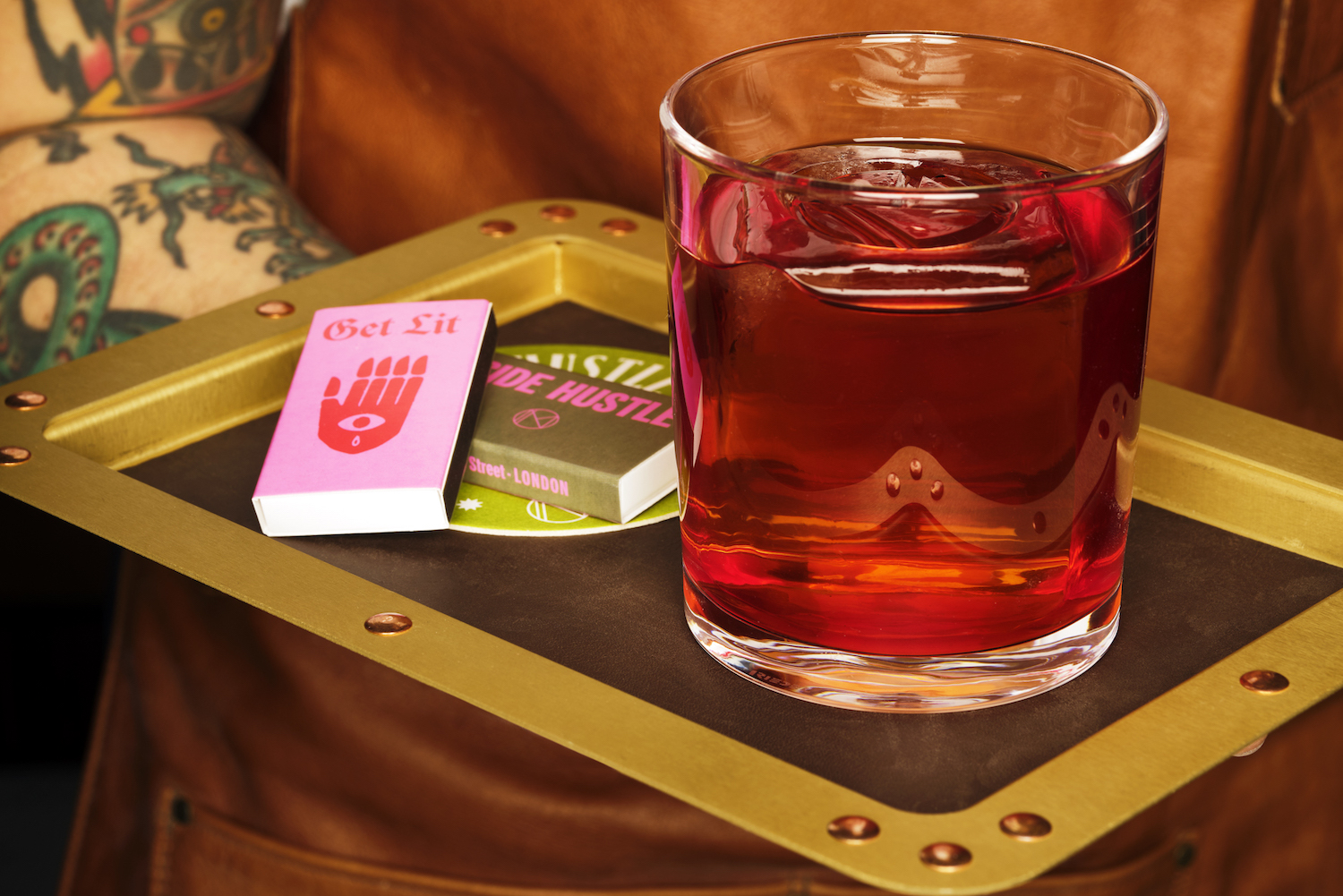 pandan negroni on a tray with match boxes