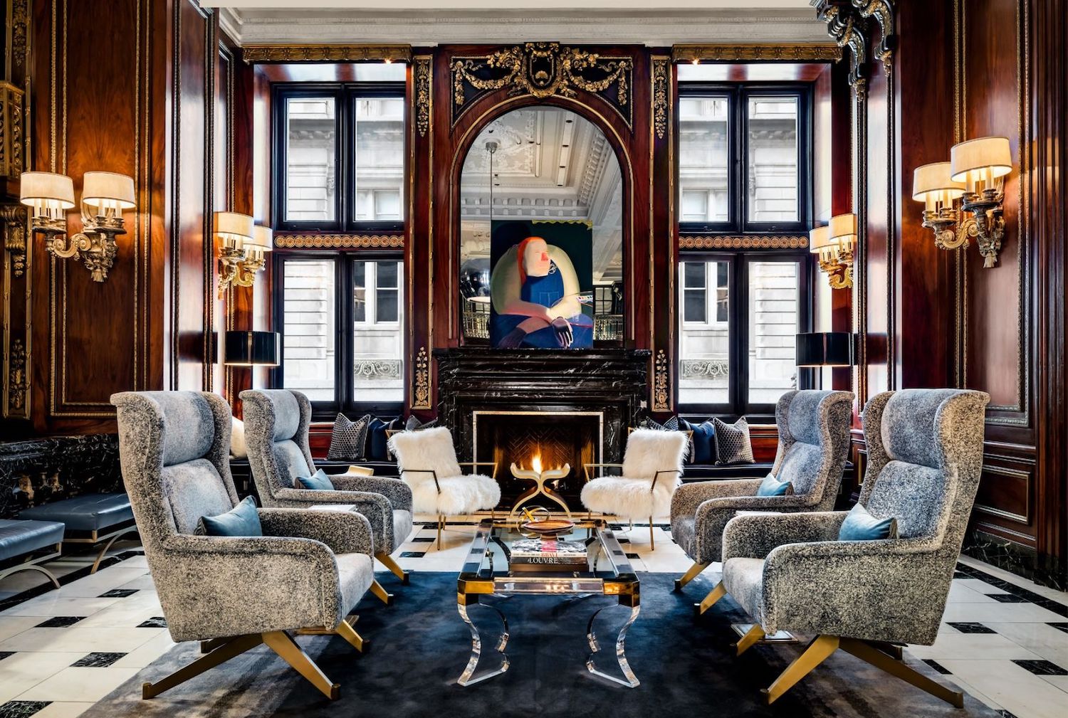 Lobby with lounge seats, wood walls and a painting overlooking scenic building.